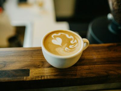 A cup of house blend coffee with a rich crema on a wooden table