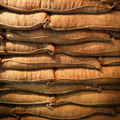 Close-up of burlap sacks of coffee beans stacked in warm light