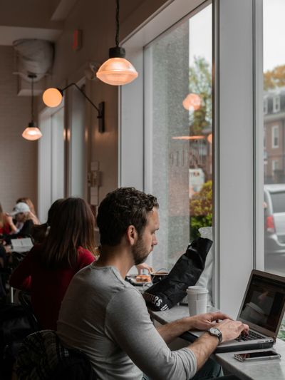 People working on laptops at a window table on a slow morning